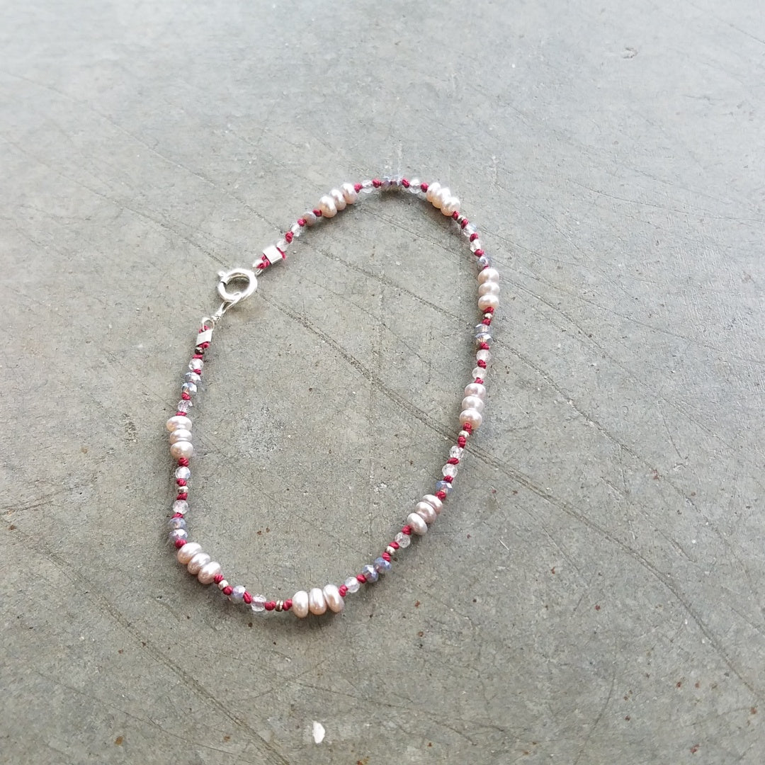 Pearls on red string bracelet