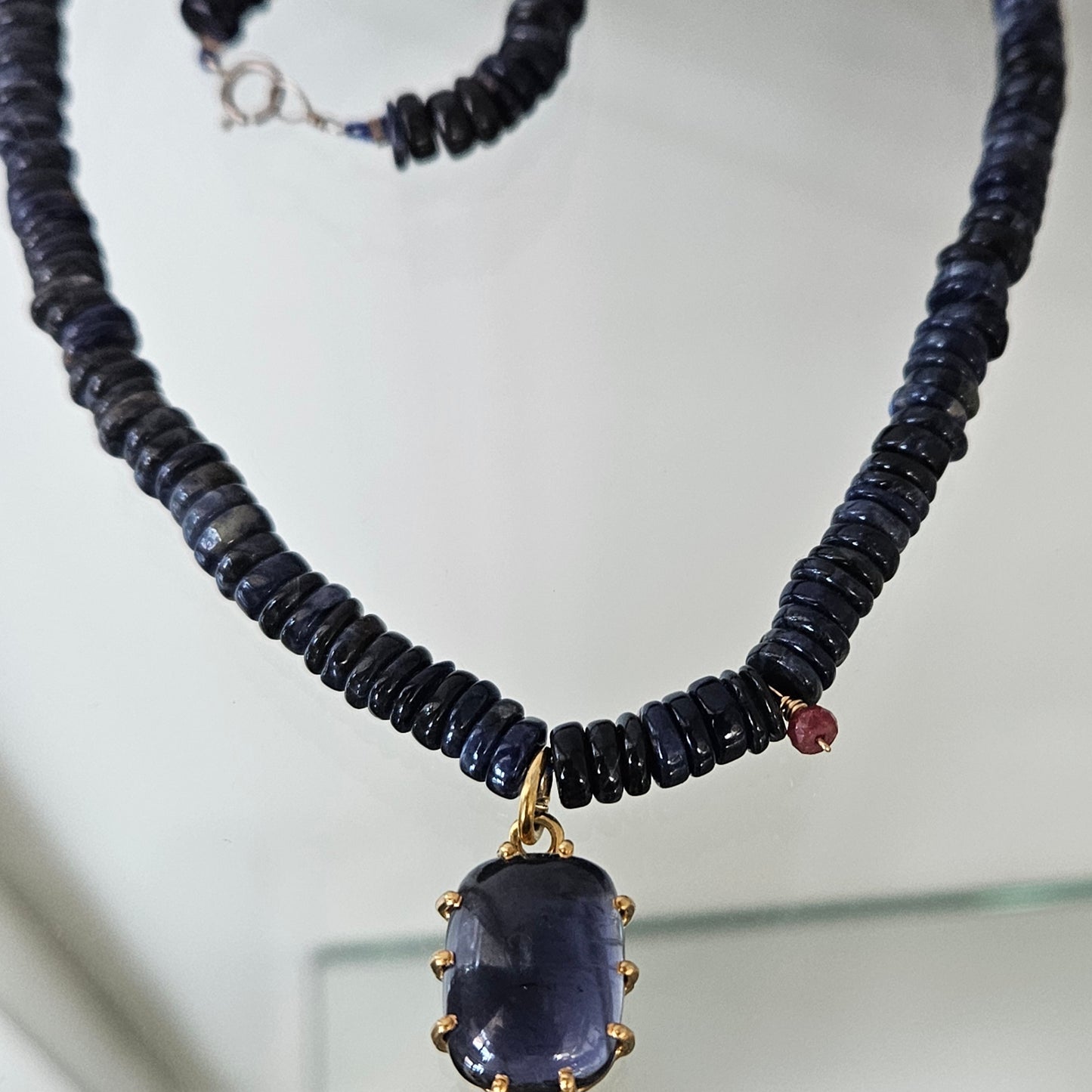 Iolite pendant on a blue necklace